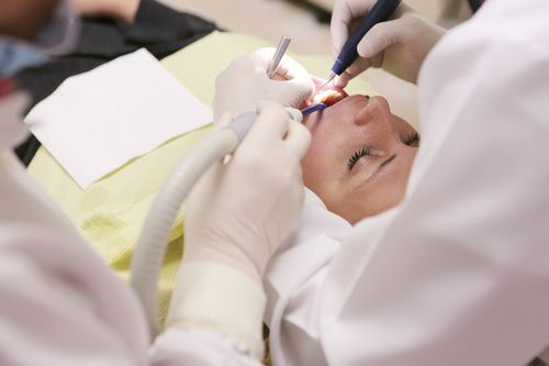 Free Close-up of a dentist performing a dental procedure on a patient in a clinic setting. Stock Photo