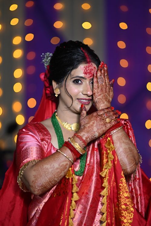Free A joyful Indian bride in vibrant attire showcases intricate henna designs during a wedding ceremony. Stock Photo