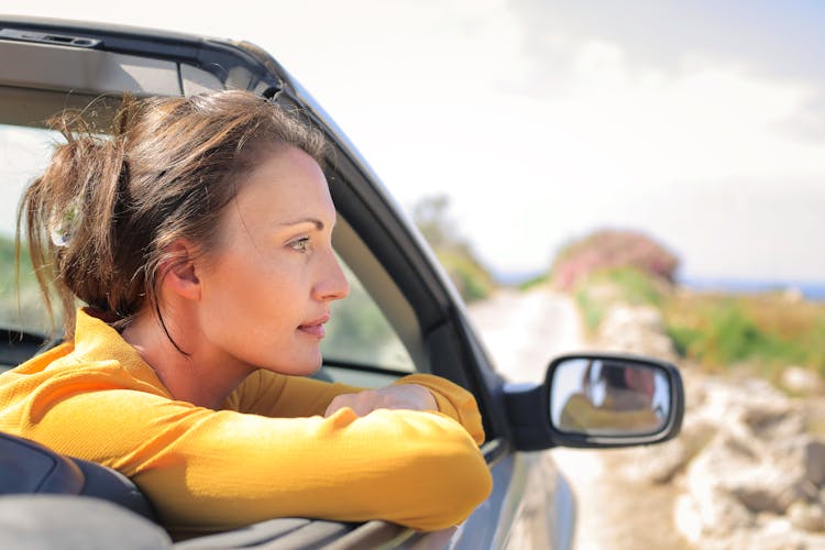 Woman In Yellow Long Sleeve Riding A Luxury Car