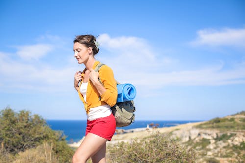 Free Woman in Yellow Long Sleeves Carrying Blue yoga mat Stock Photo