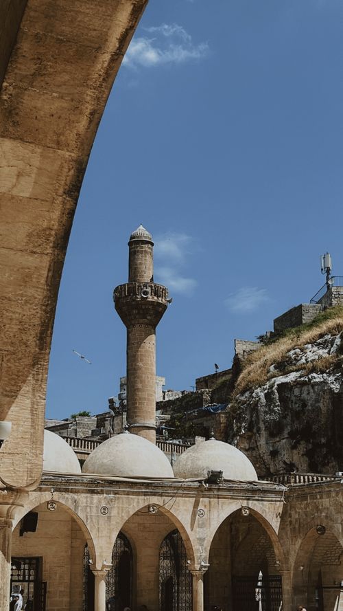 Free Majestic stone minaret and domed architecture under a vivid blue sky, embodying historical charm. Stock Photo