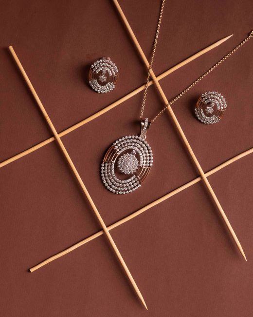 Elegant diamond jewelry set featuring a necklace and earrings on a brown backdrop.