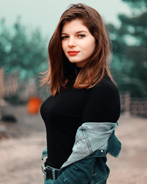 Free A young woman poses outdoors with a confident smile and vibrant red lips. Stock Photo