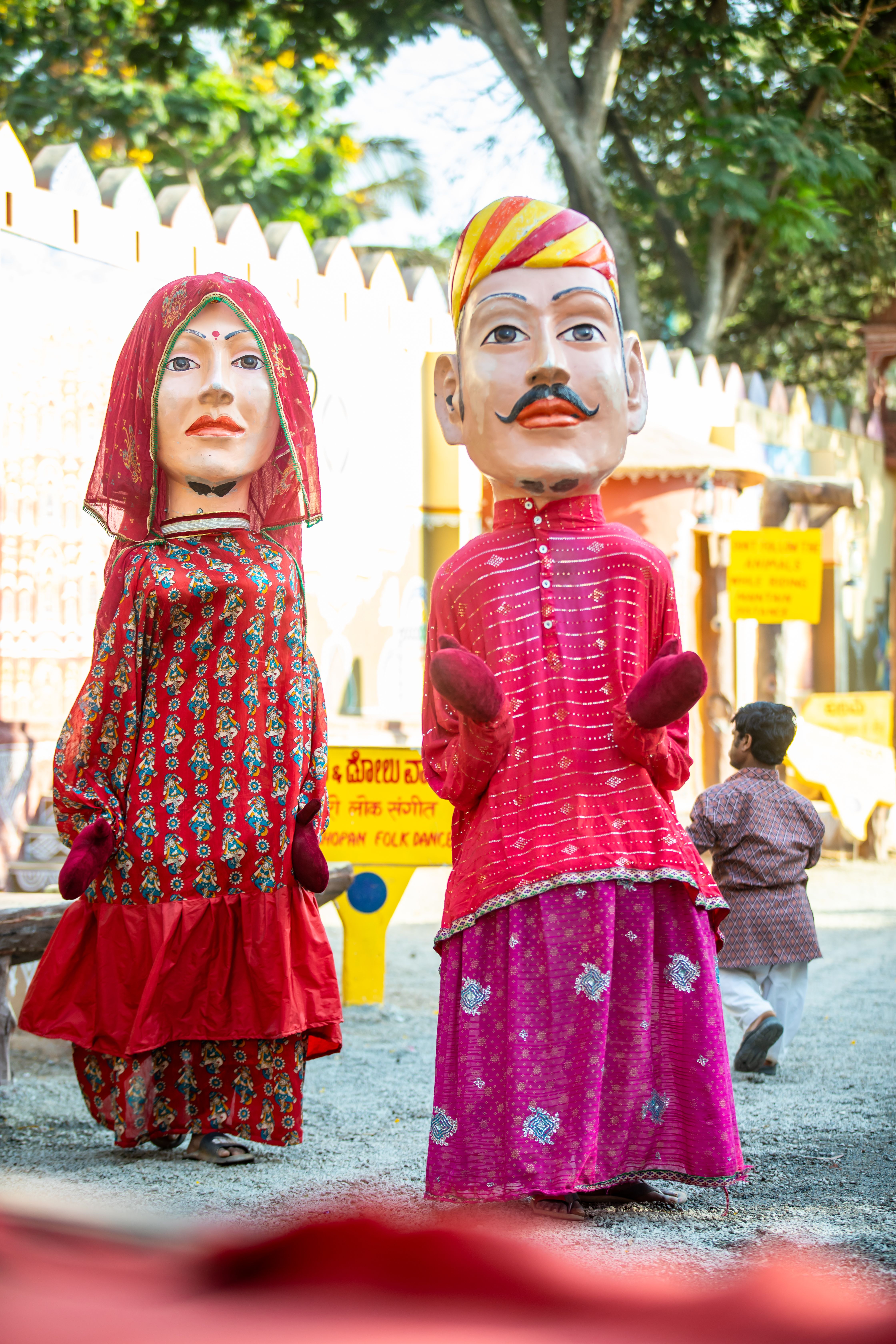 Colorful Rajasthani puppets displayed outdoors in cultural setting, showcasing traditional artistry.
