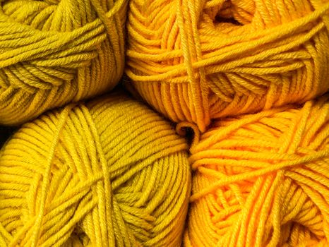 Vibrant close-up of bright yellow yarn balls, ideal for knitting and craft enthusiasts.