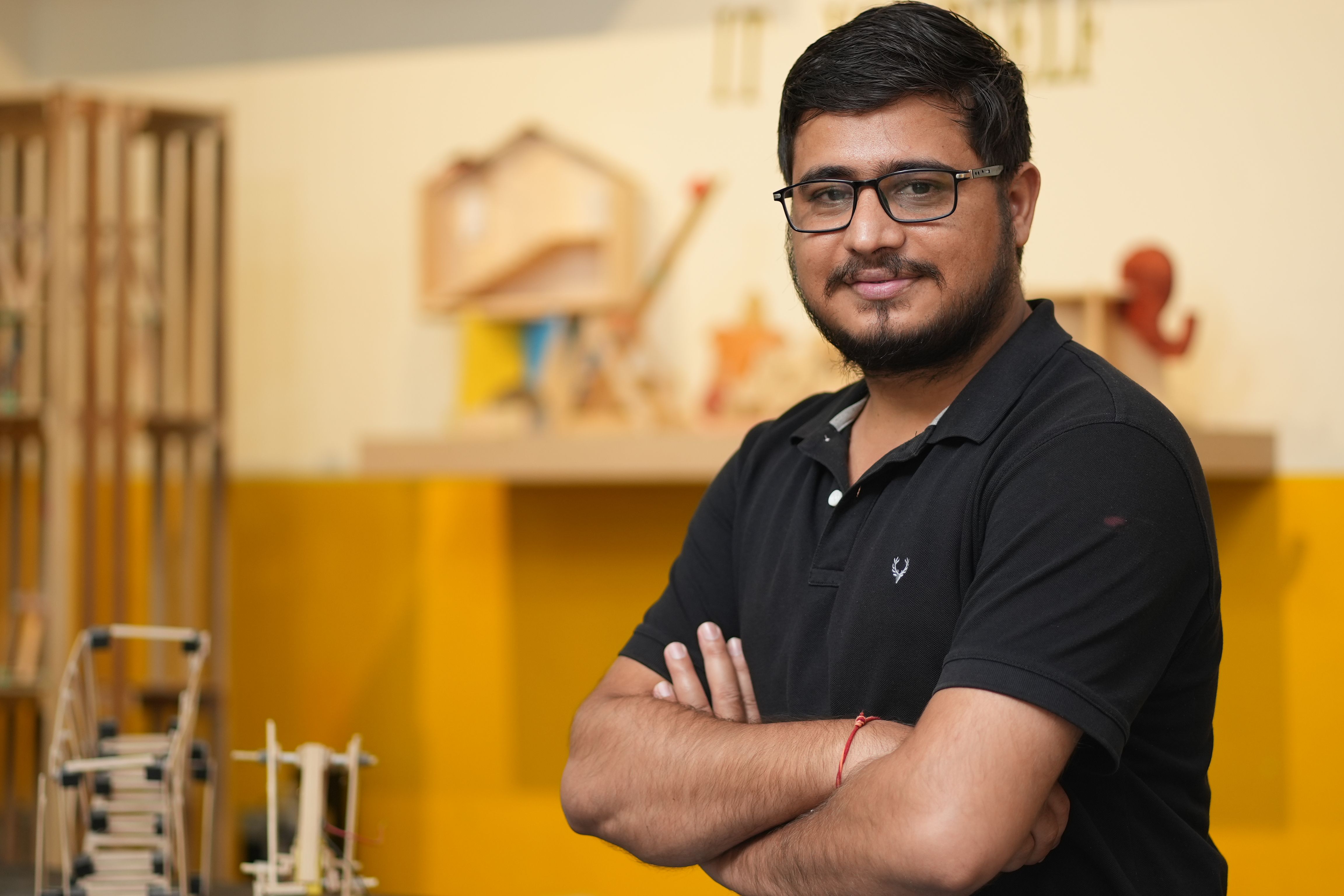 Portrait of a confident man with glasses in a creative indoor workspace. Ideal for business or educational imagery.