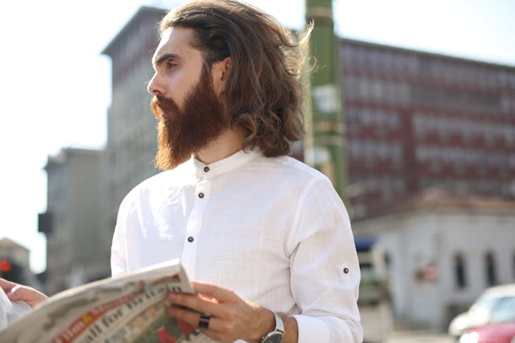 Man In White Long Sleeves Holding A News Paper