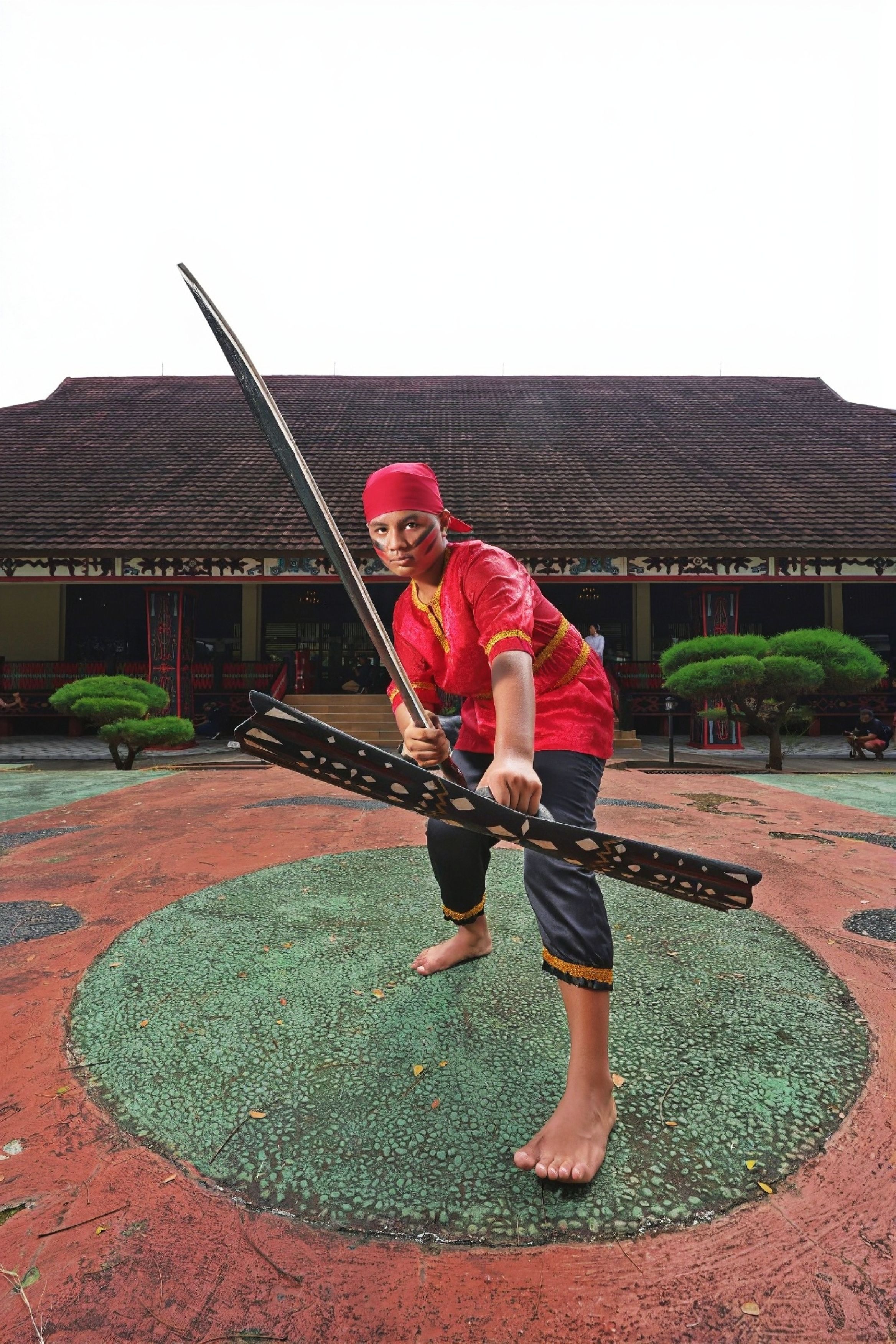 Martial artist in traditional attire displaying skill with sword in Jakarta, Indonesia.
