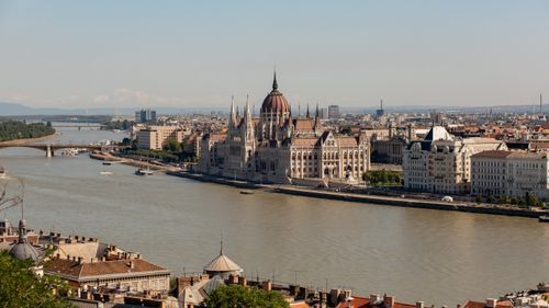 Free A stunning aerial view of the Hungarian Parliament Building and Danube River in Budapest under a clear sky. Stock Photo