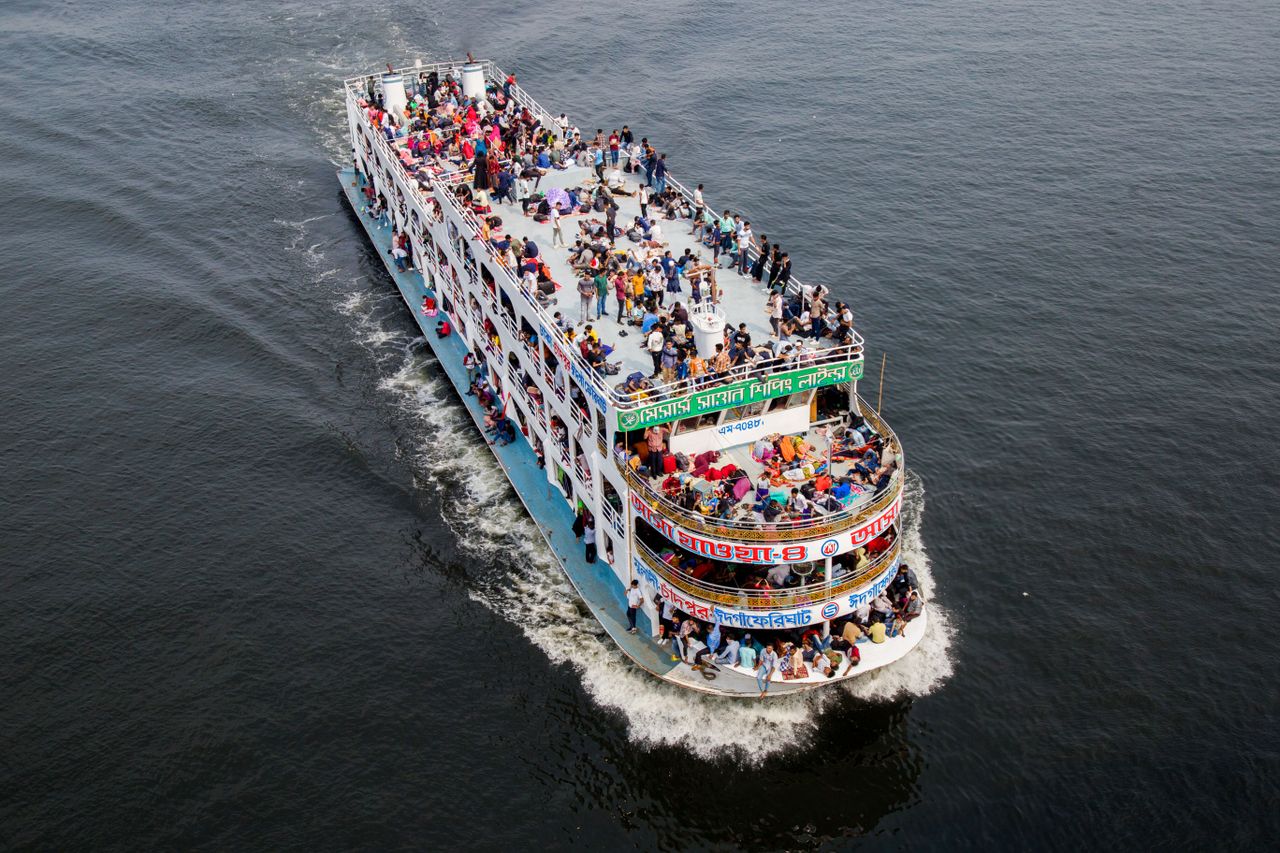 aerial photo of a crowded passenger ferry navigating a body of water f