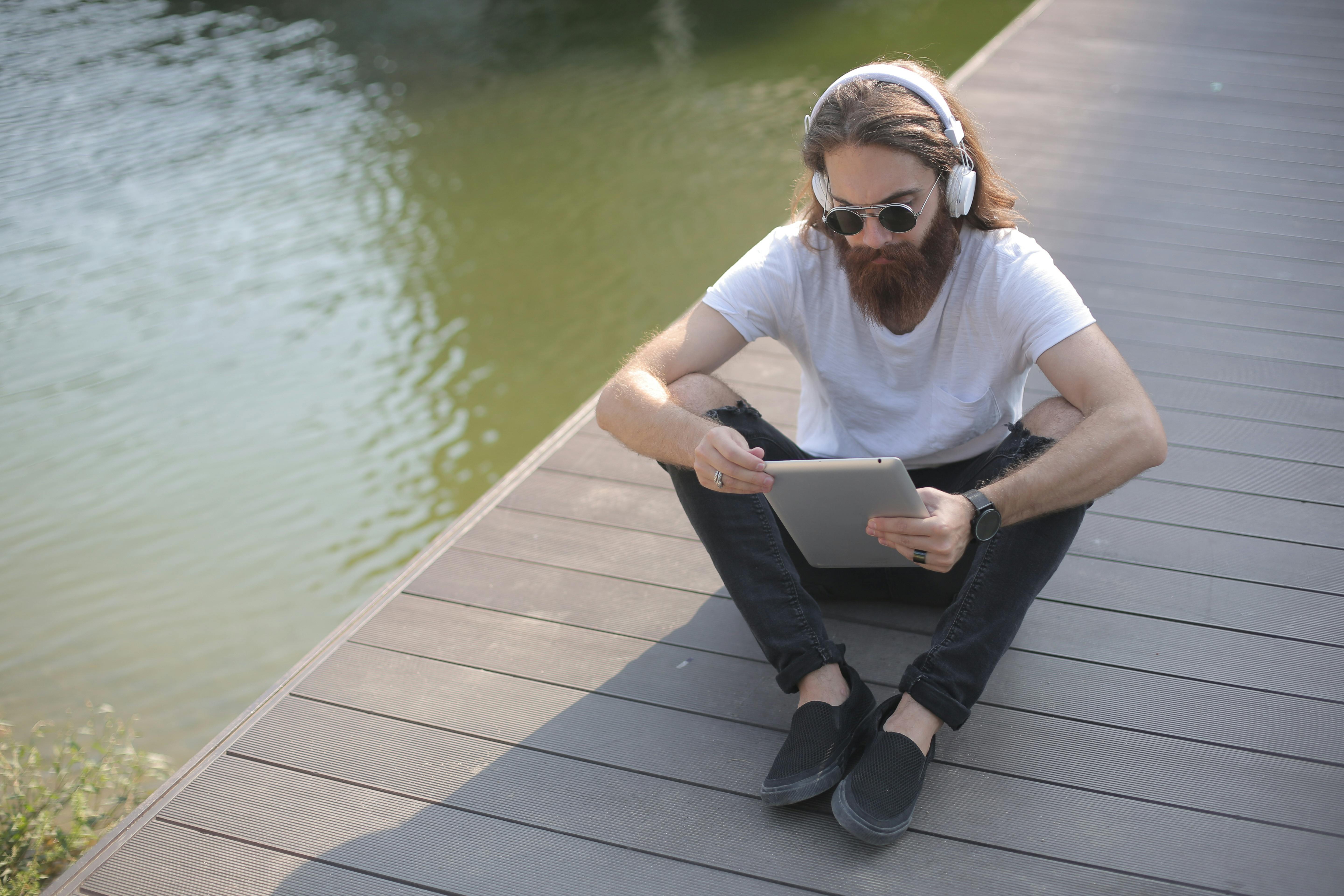 man wearing white shirt and black jeans listening to music