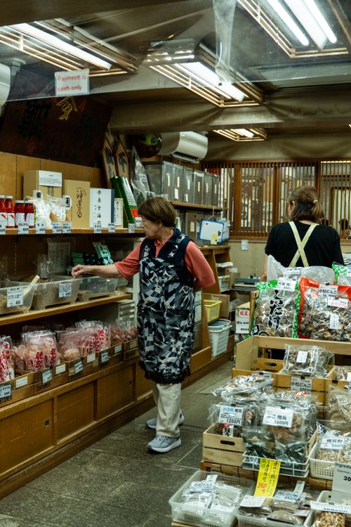Free Women exploring a traditional Japanese grocery store, browsing various authentic products. Stock Photo