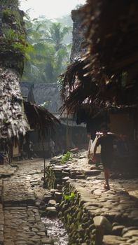 Scenic view of a traditional stone pathway in a rural village in Banten, Indonesia. Tropical greenery surrounds the rustic scene. - Fotografer Sidoarjo