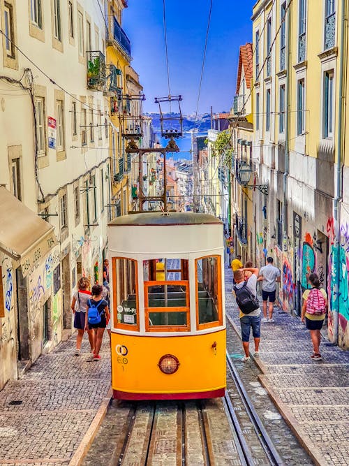 People Walking on Street Near Yellow Tram