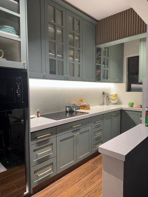 Free Sleek modern kitchen with grey cabinets, marble countertops, and warm lighting for a cozy ambiance. Stock Photo