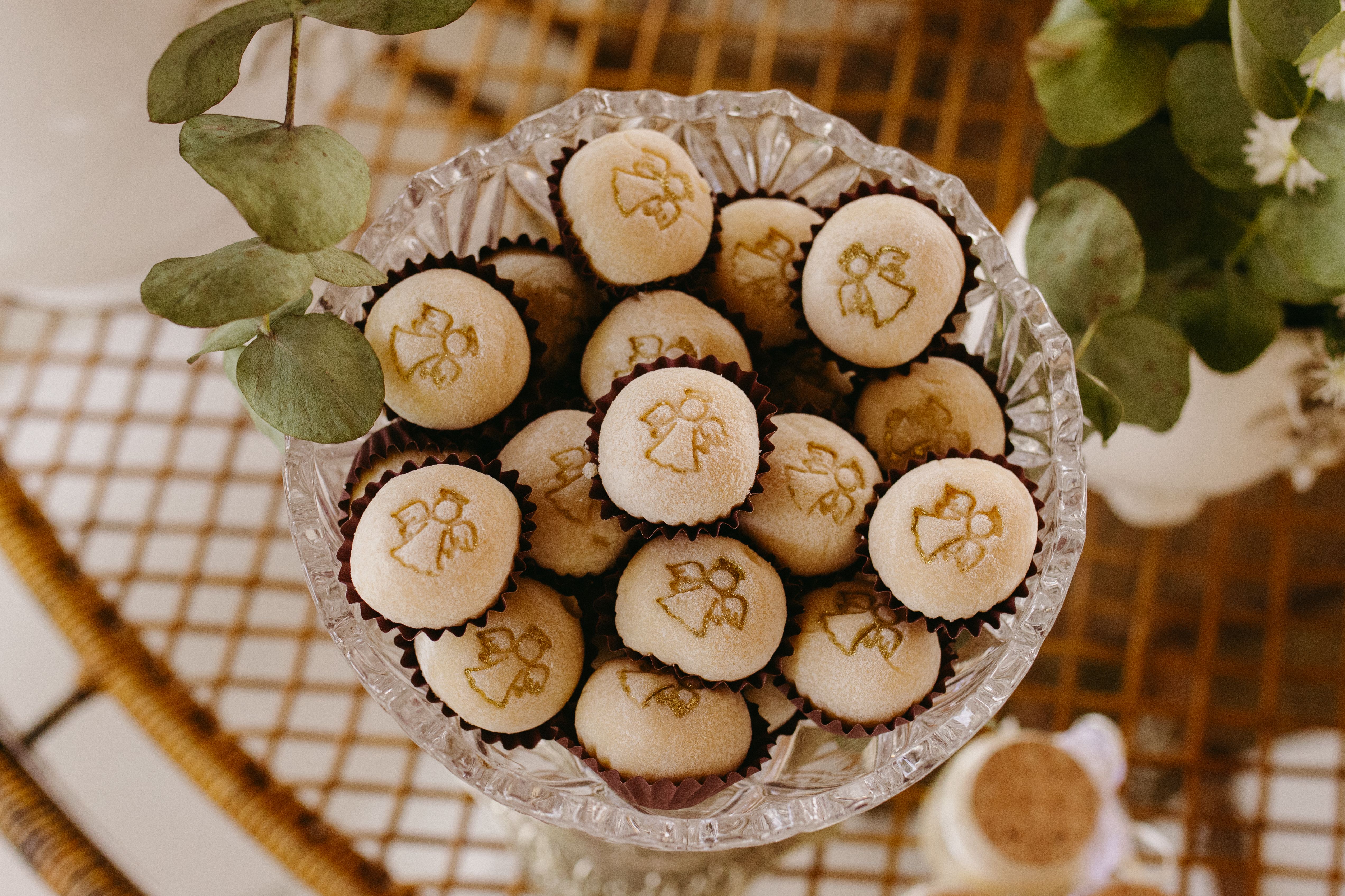 A crystal bowl filled with decorated wedding cookies featuring angel motifs, perfect for a wedding event.