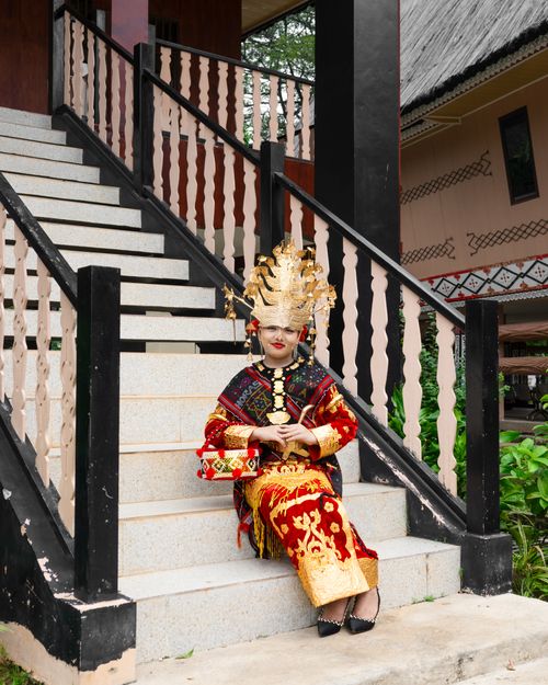 Free Woman in traditional attire sitting on stairs outdoors, showcasing cultural heritage. Stock Photo
