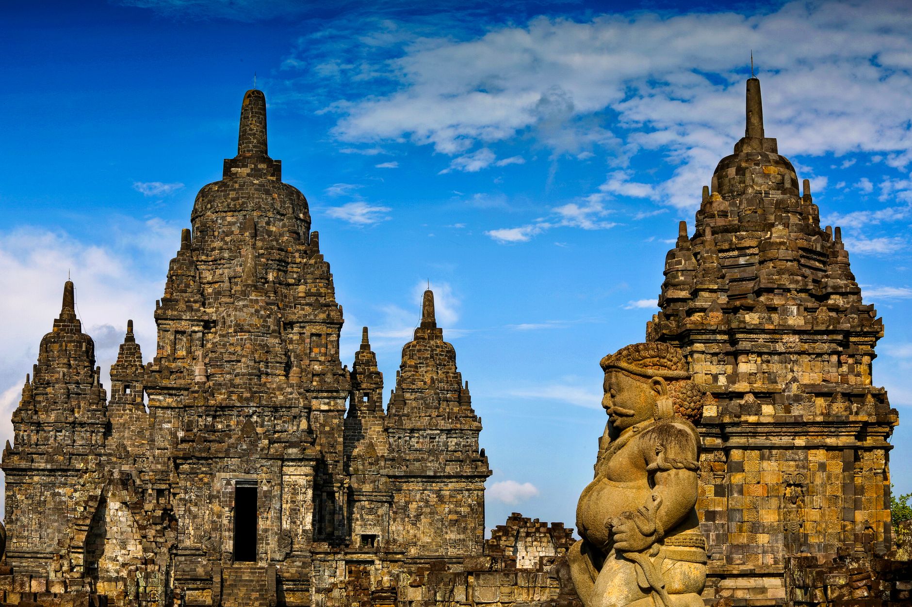 Ancient Sewu Temple complex under a bright blue sky in Yogyakarta, Indonesia.