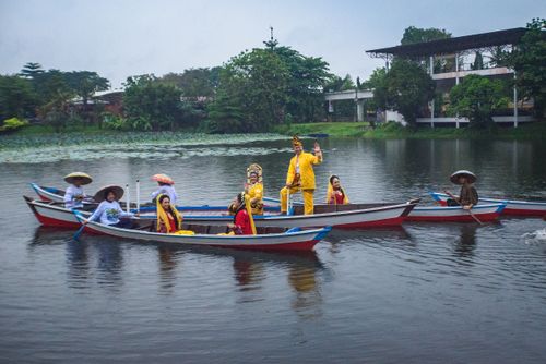 Free Traditional boats with people in cultural attire on a serene river. Stock Photo