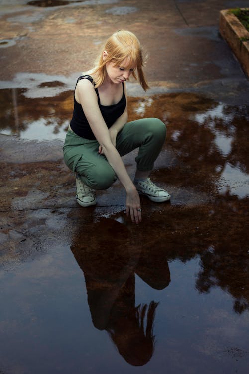 Femme En Débardeur Noir Touchant L'eau