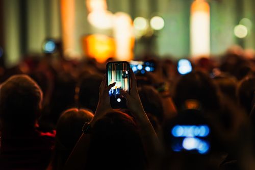 Free Audience recording live concert with smartphones, vibrant and energetic atmosphere. Stock Photo