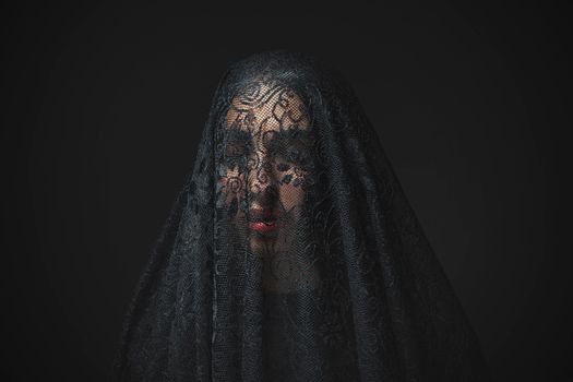 A portrait of a woman with a delicate lace veil, creating an air of mystery and elegance.