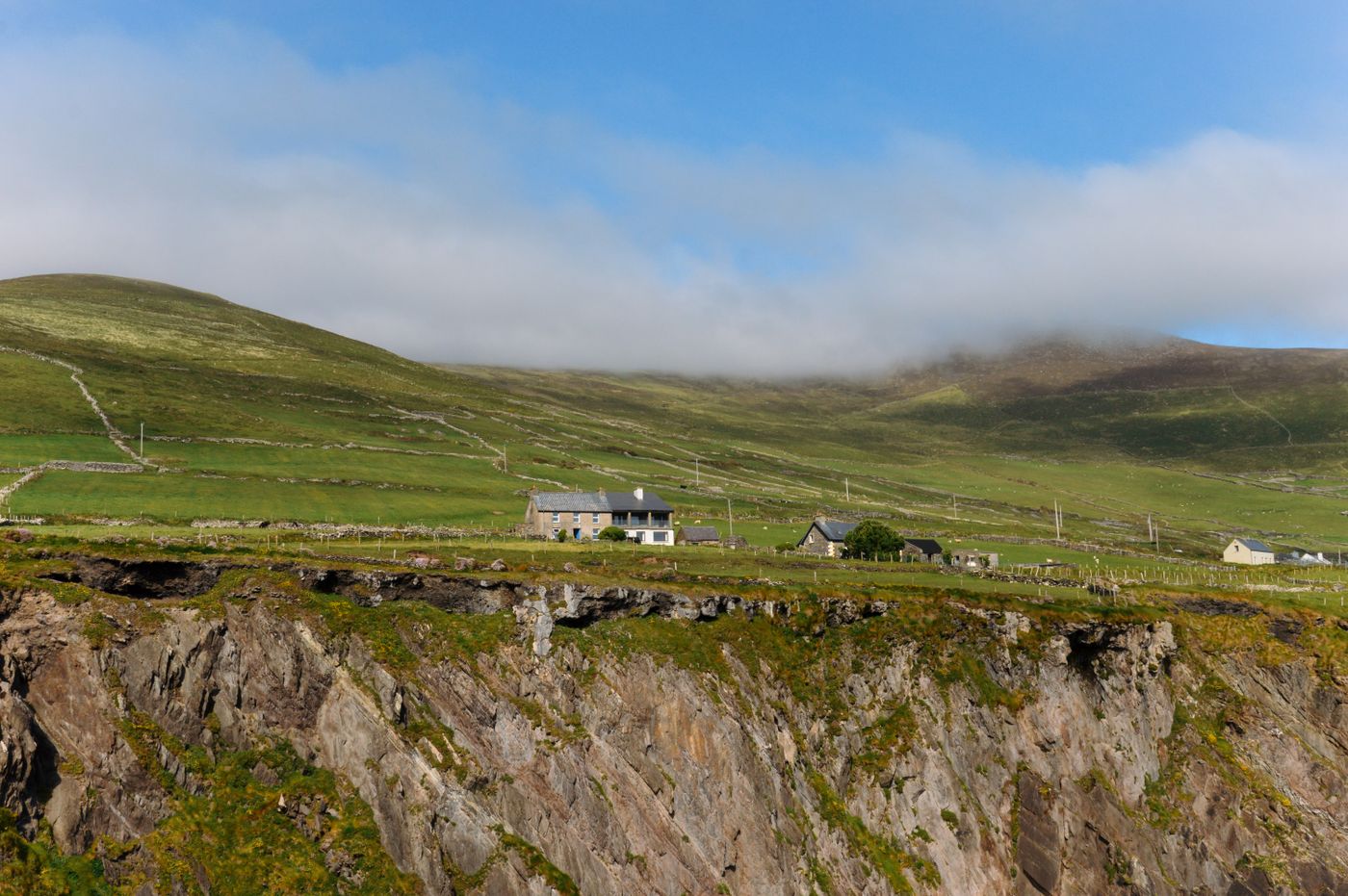 Autocar d’excursion sur la route côtière du Ring of Kerry, cottage et falaises verdoyantes du Kerry