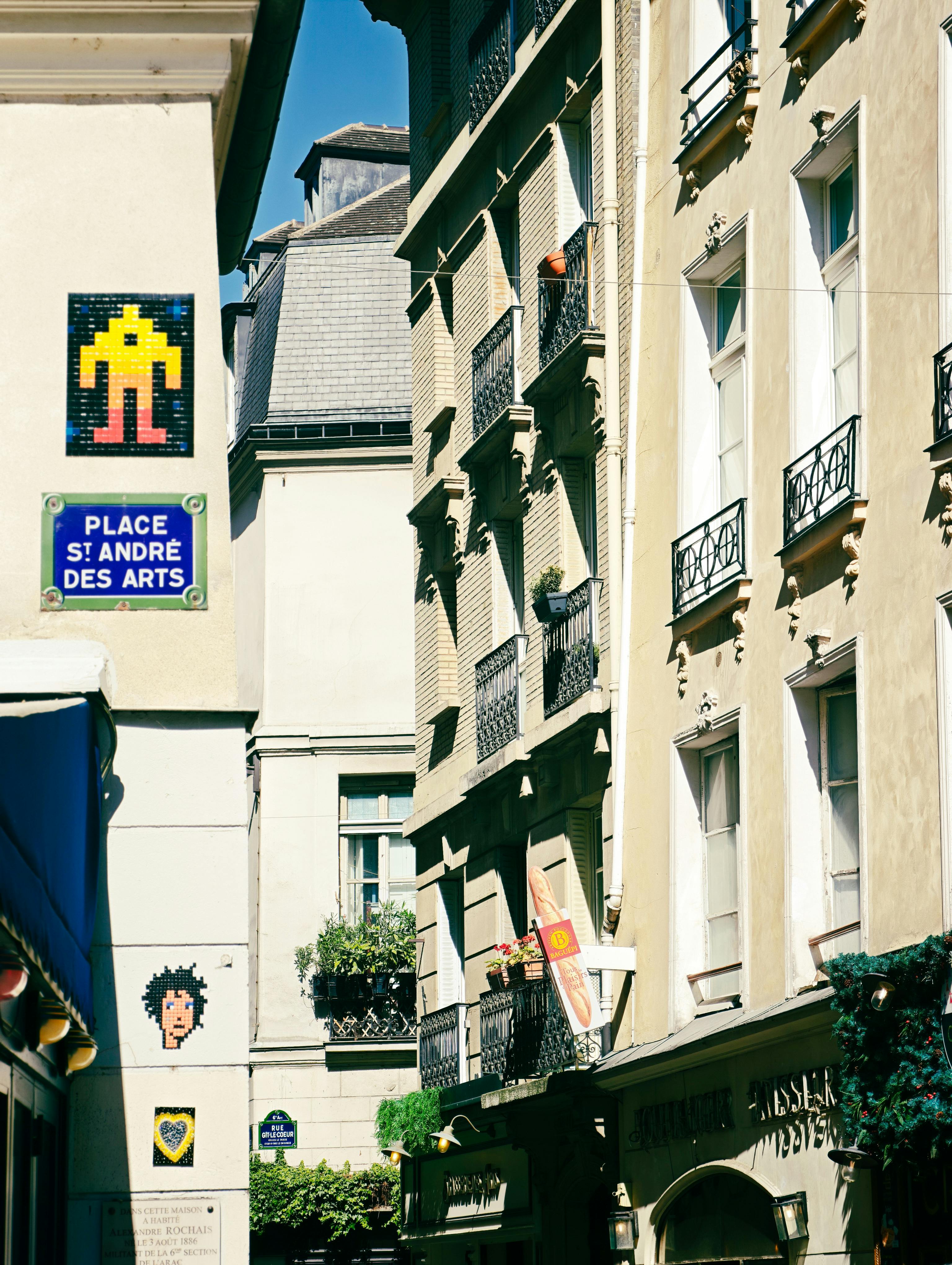 Sunny day view of Place St André des Arts, showcasing Parisian architecture and urban street art.