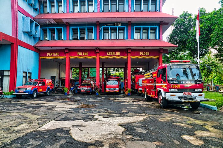 Fire Trucks Parked On Blue And Red Building