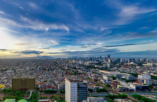Free Stunning aerial view of Jakarta's cityscape at dusk, capturing its modern skyline and urban sprawl. Stock Photo
