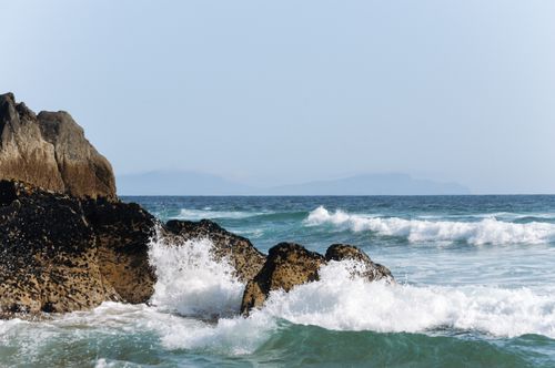 Free Waves crashing against rugged rocks on the Irish coastline, capturing nature's raw power. Stock Photo