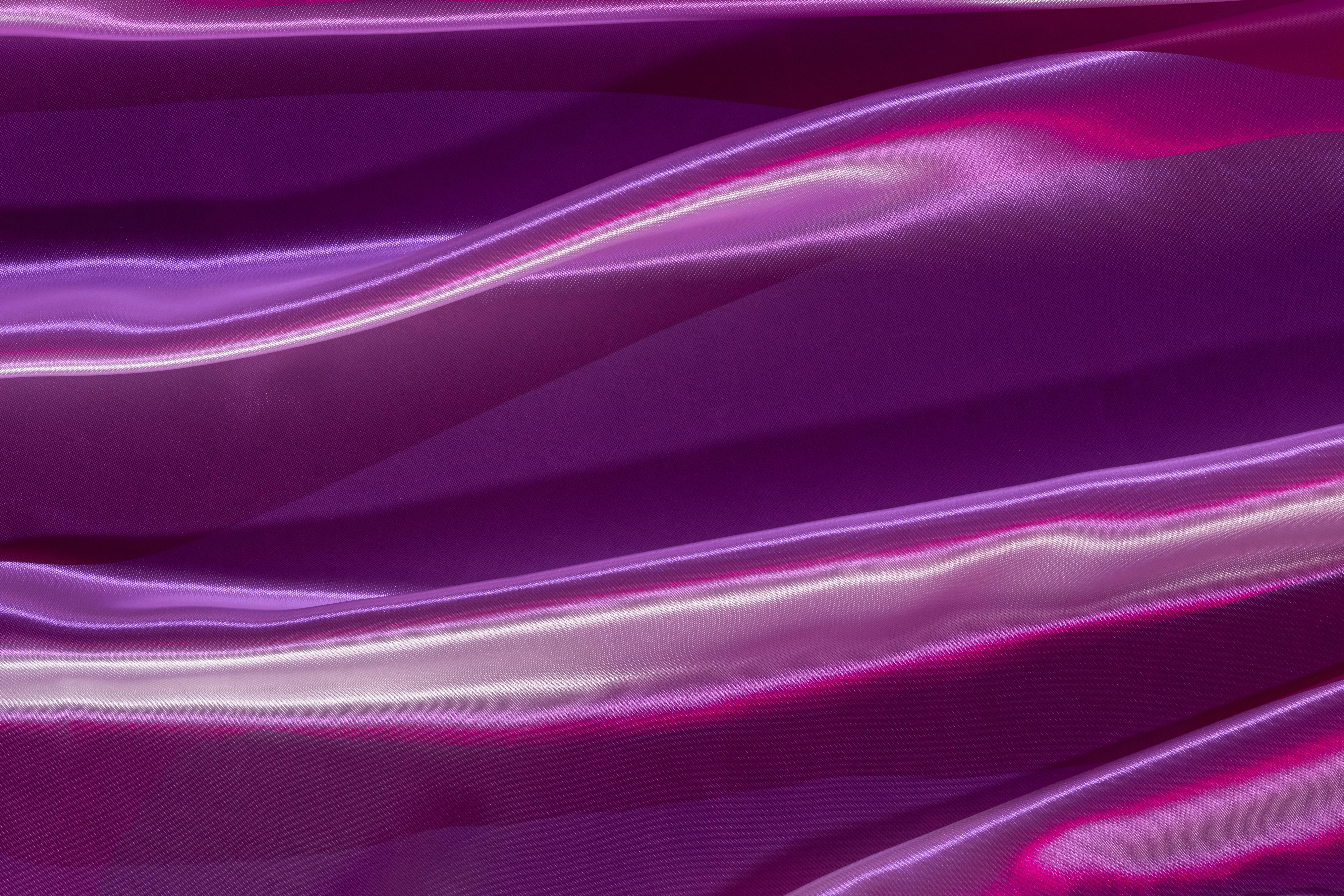 Close-up of shimmering purple satin fabric creating an elegant, silky texture.