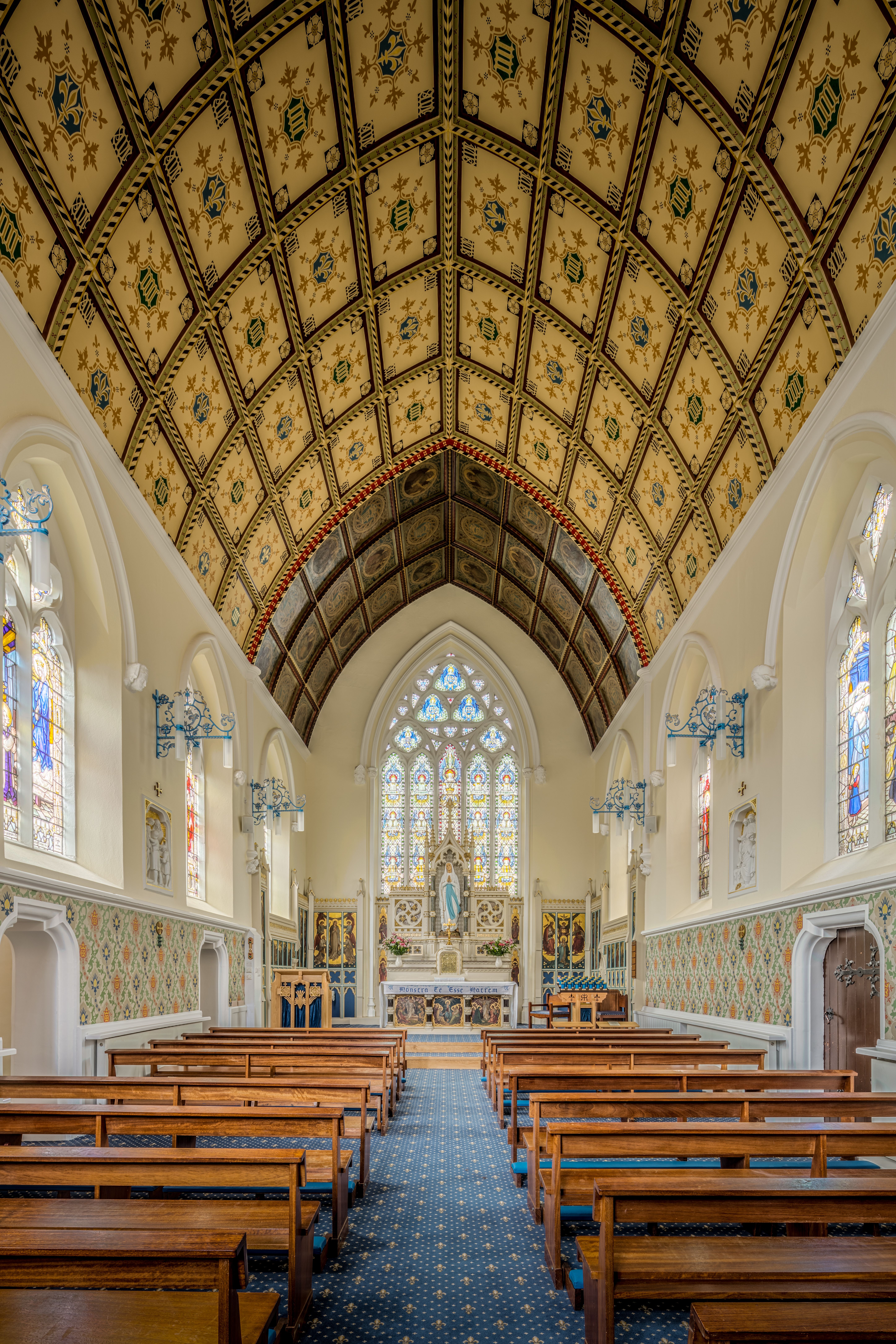 Stunning view of a Gothic chapel with decorative ceiling and stained glass windows in England.