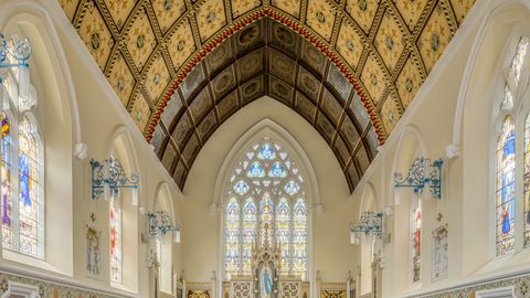 Stunning view of a Gothic chapel with decorative ceiling and stained glass windows in England.
