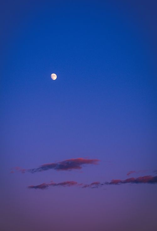 Free A serene moonlit twilight scene with gentle clouds and vibrant hues. Stock Photo
