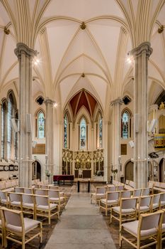 Stunning Gothic church interior with stained glass and arches in England.