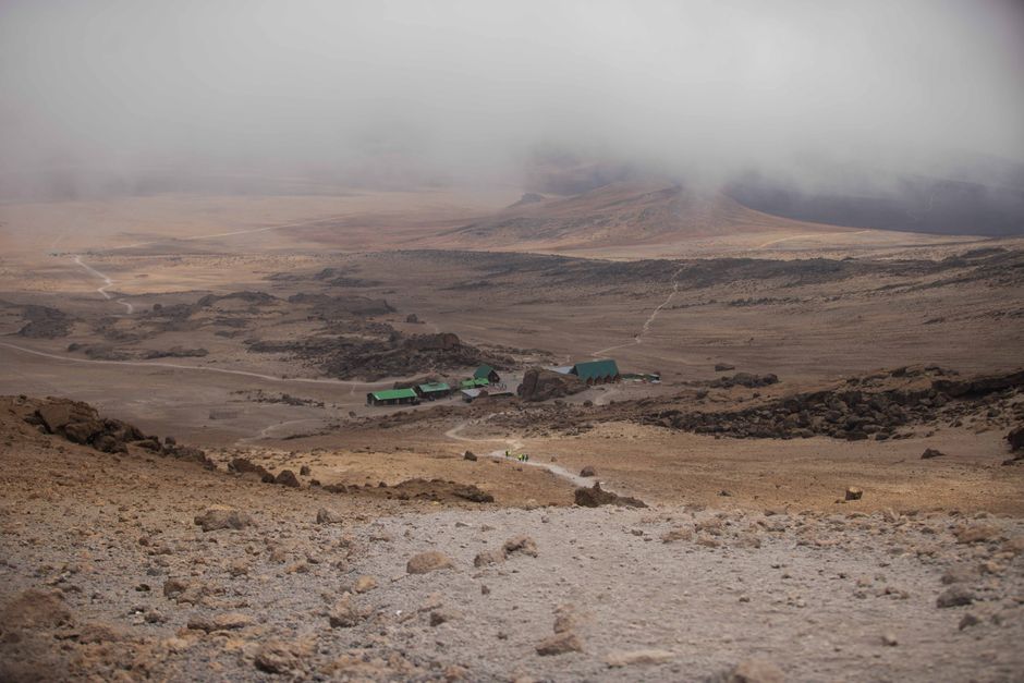 Incredible 7 Days Mount Kilimanjaro Climbing via Machame Route Review 2026 - A misty and barren landscape in Mount Kilimanjaro National Park with huts visible.