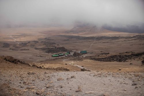 Free A misty and barren landscape in Mount Kilimanjaro National Park with huts visible. Stock Photo