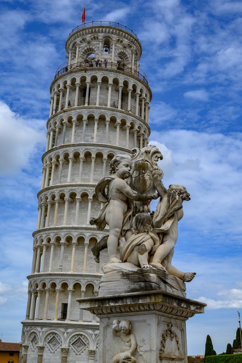 Free Iconic view of the Leaning Tower of Pisa with decorative cherub statues under a vibrant sky. Stock Photo