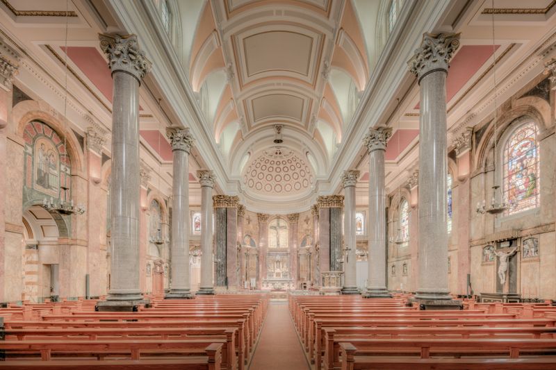 Majestic church interior showcasing columns and stained glass in England, highlighting its architectural beauty.