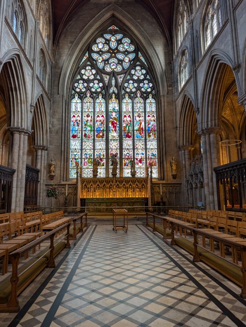 Free Majestic Gothic cathedral interior featuring intricate stained glass and vaulted ceilings. Stock Photo