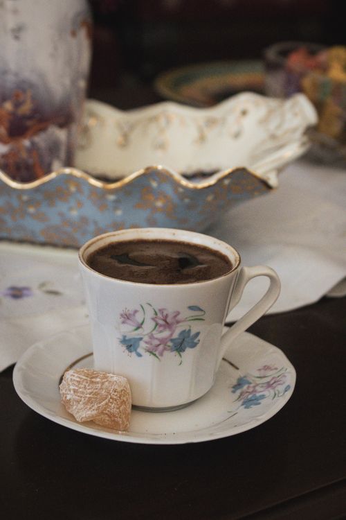 Free Cozy table setting featuring coffee in a floral teacup paired with Turkish delight. Stock Photo