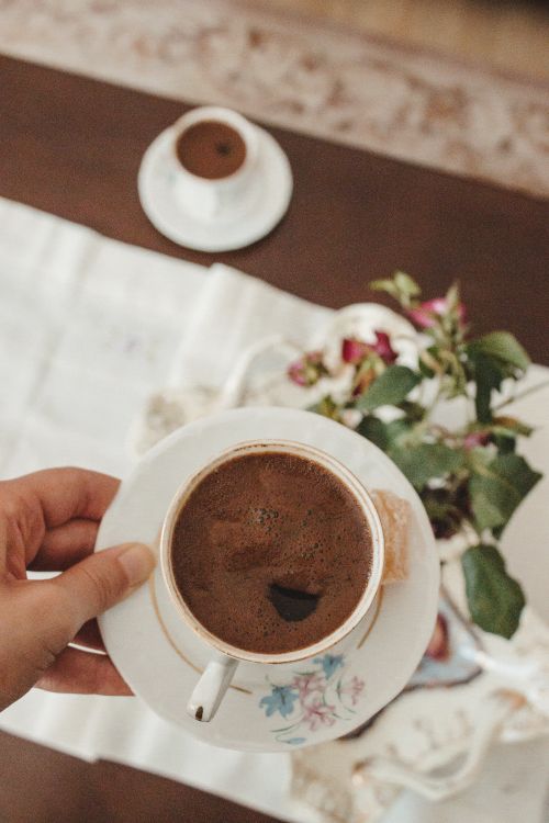 Free A morning coffee moment with delicate flowers on a wooden table. Stock Photo