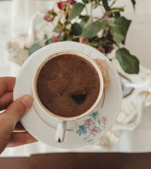 Free A cozy close-up of Turkish coffee in a floral cup and saucer setting. Stock Photo