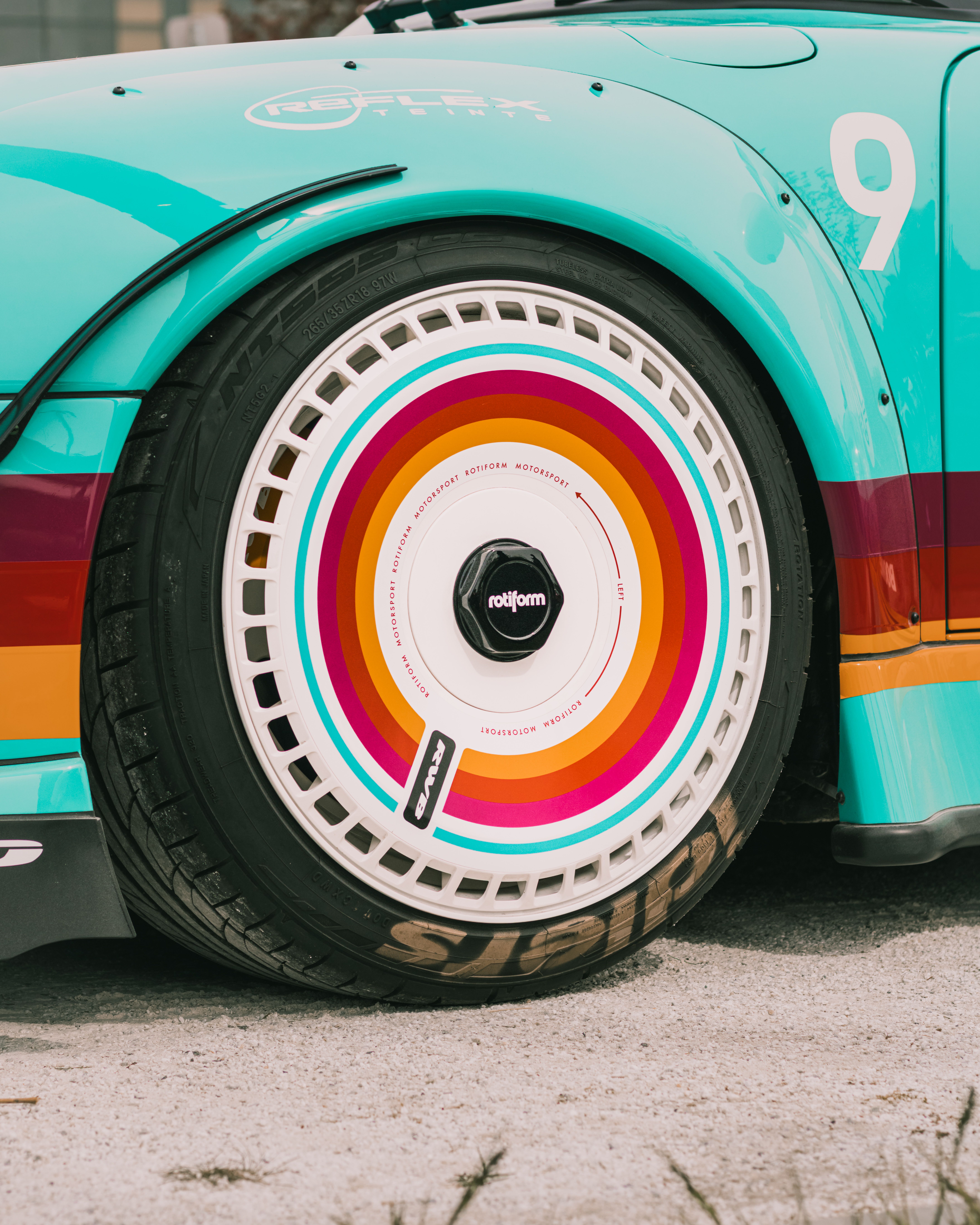 Close-up of a colorful, custom car wheel with a circular rainbow design in Montreal.