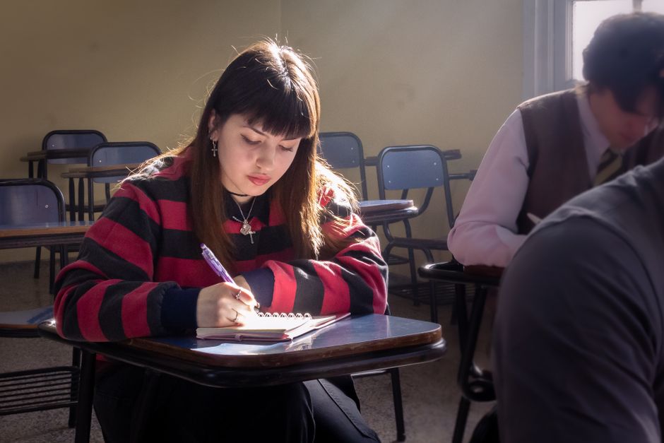 Young woman writing in notebook during class in Buenos Aires, Argentina.