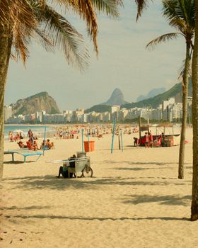 Sunny day at Copacabana Beach with view of Rio's skyline and Sugarloaf Mountain.
