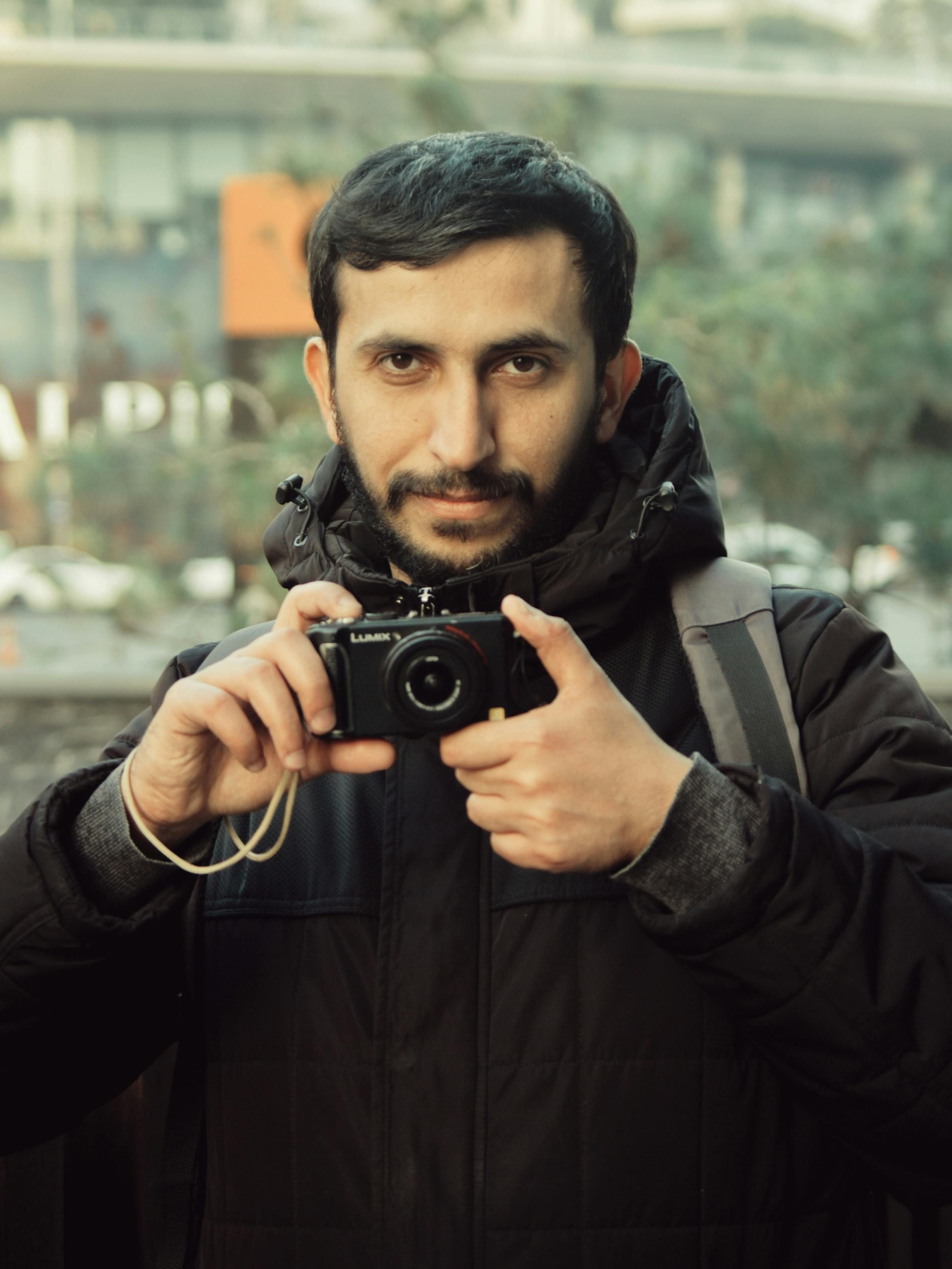 Portrait of Photographer Holding a Camera Outdoors