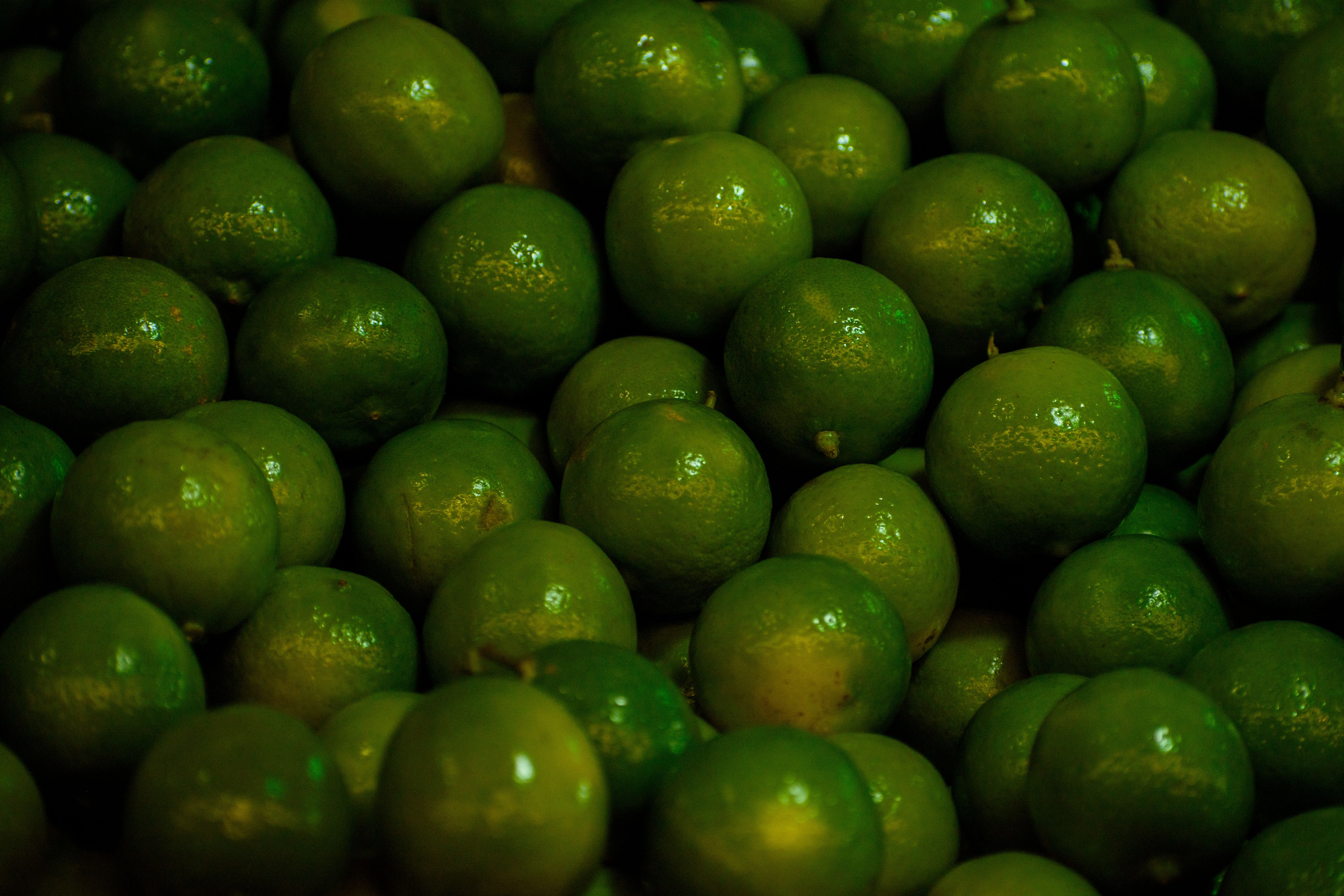 Preparation of fresh lime juice with a juicer and limes on wooden table