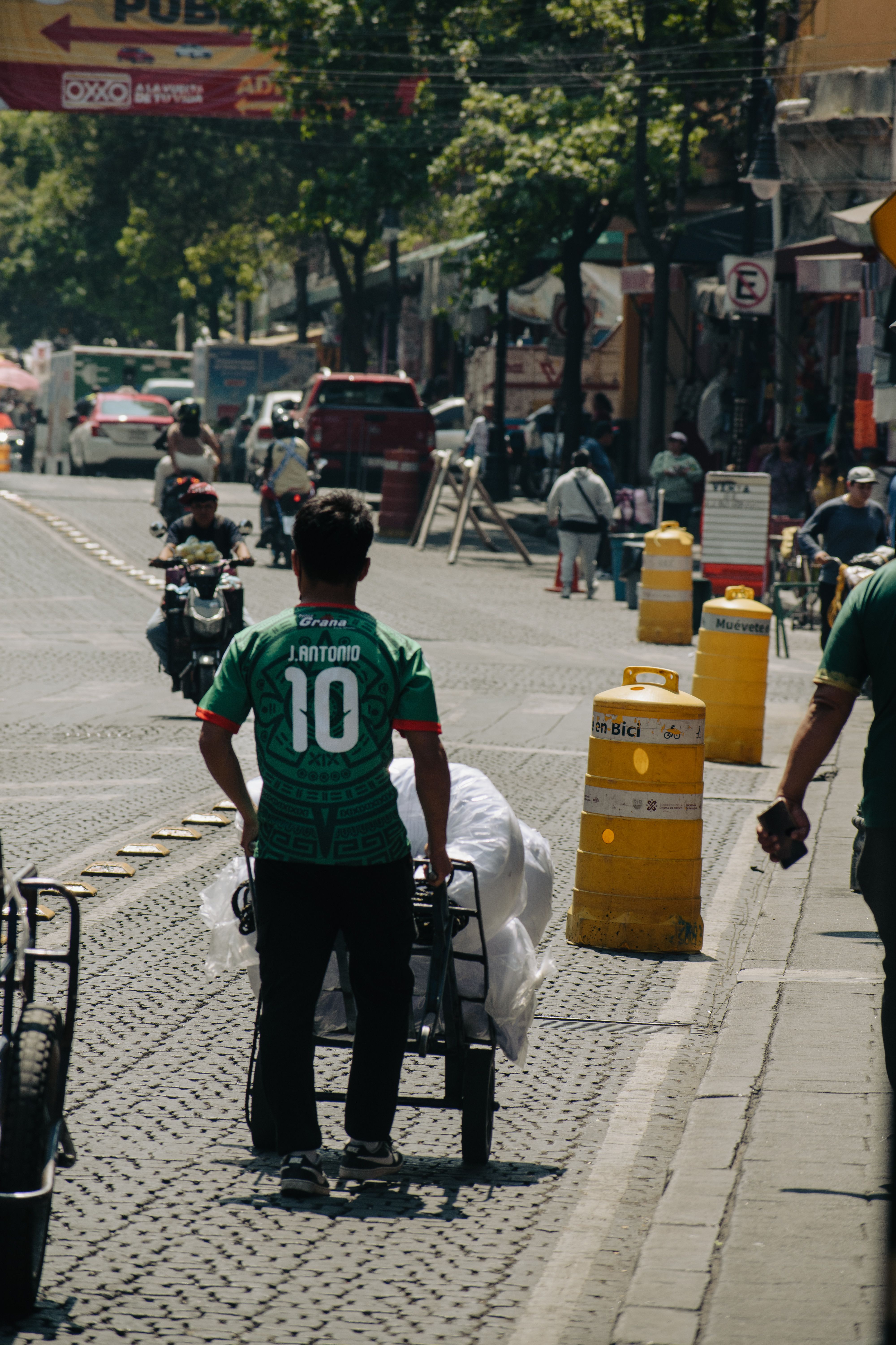 Busy street in Ciudad de México featuring street vendors and bustling activity on a sunny day.